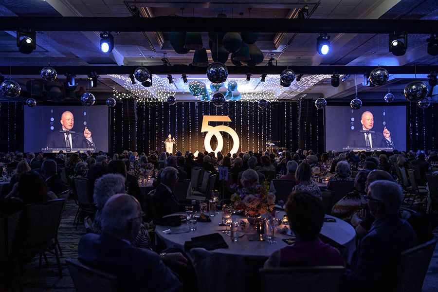 The image shows people seated at a dinner