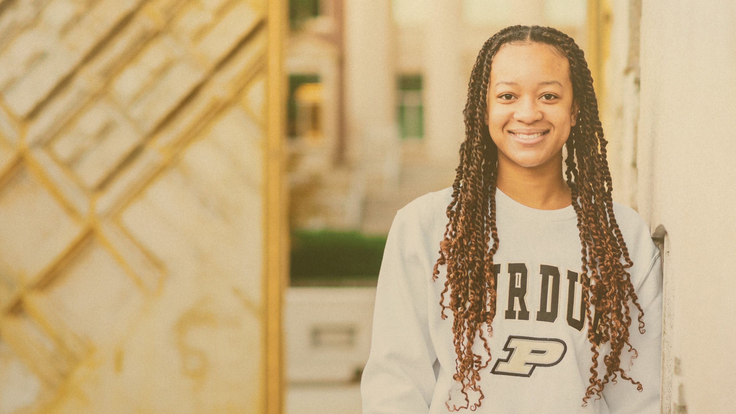 The image shows a smiling Purdue student