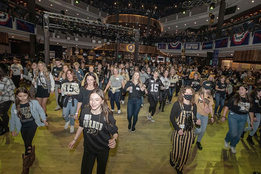 The image shows fans at the bowl game tailgate