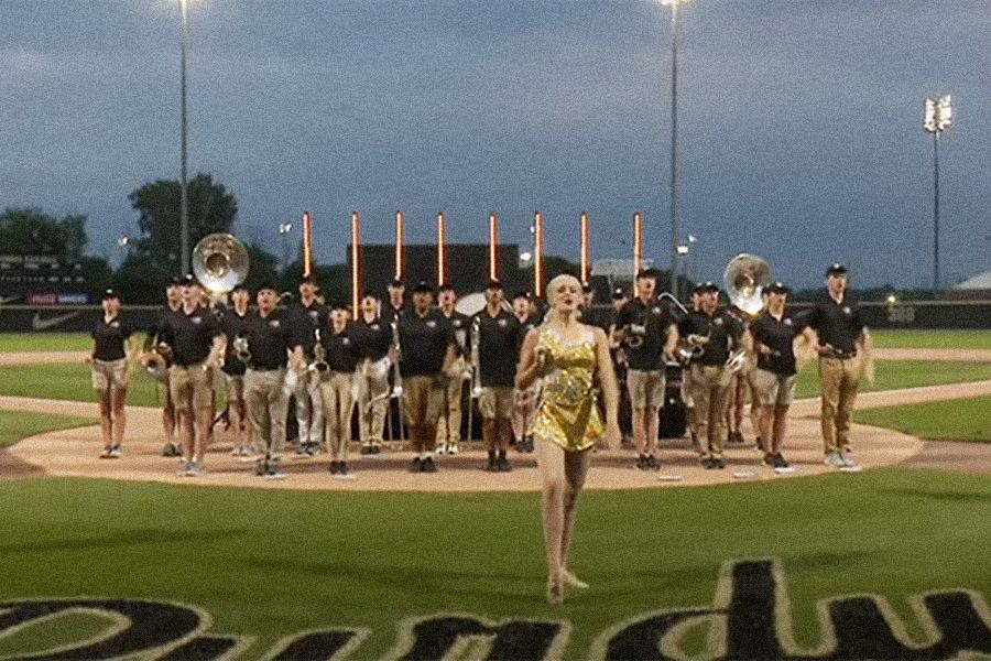 The image shows the Golden Girl and members of Purdue Bands & Orchestras