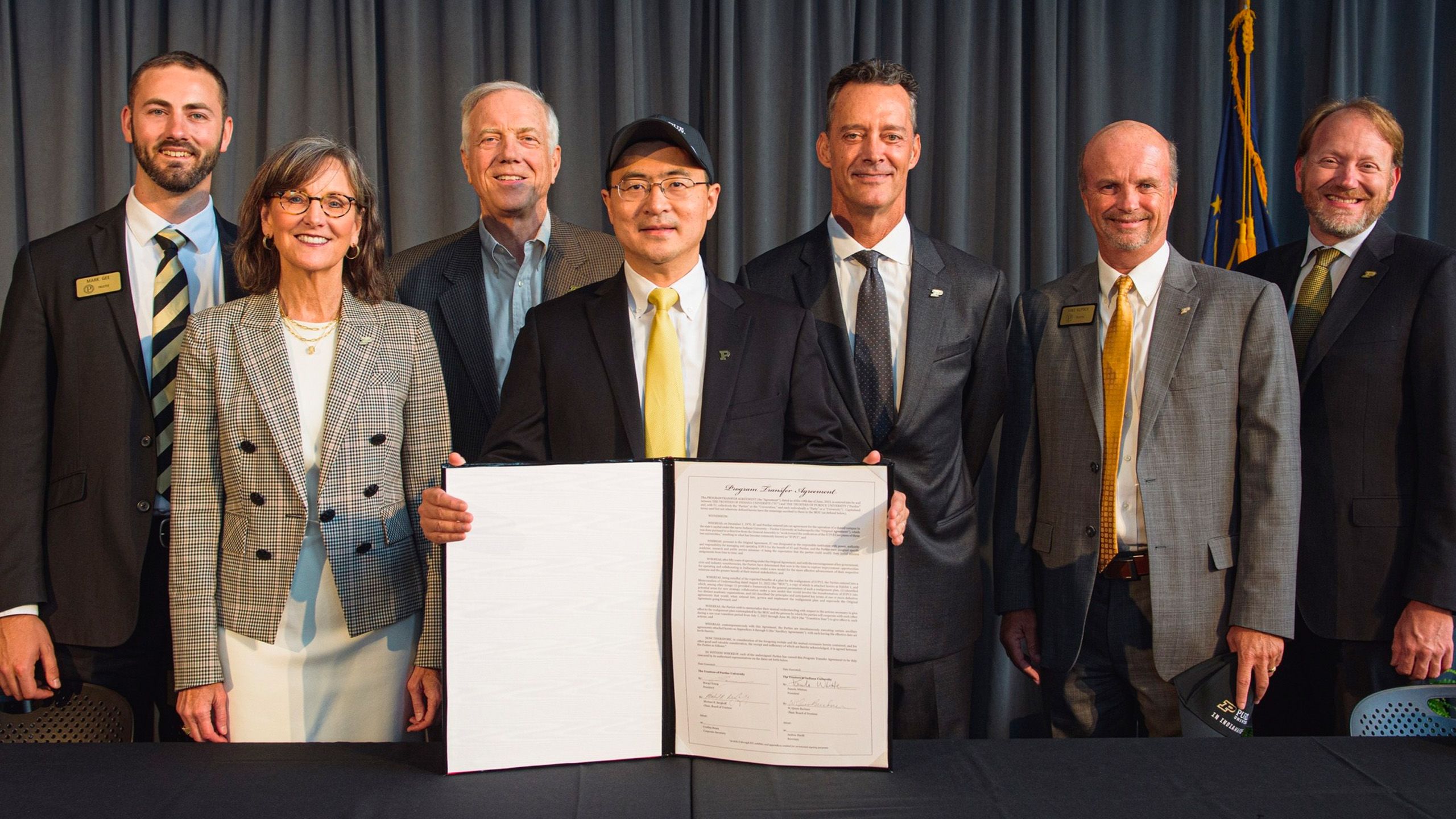 President Chiang poses with a group of leaders and holds the signed agreement to dissolve IUPUI