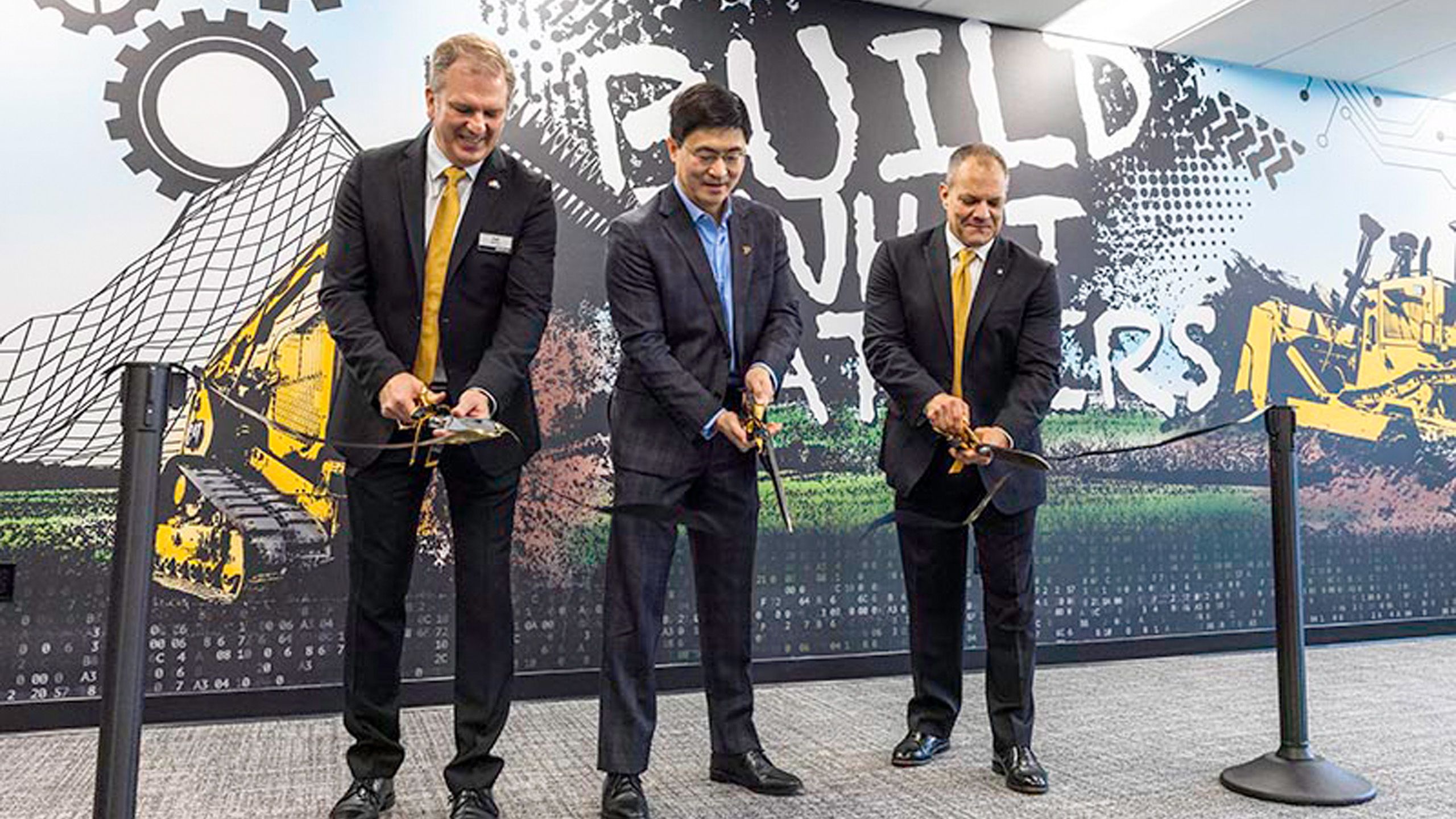 Karl Weiss, senior vice president and chief technology officer at Caterpillar; Purdue President Mung Chiang; and Paul Rivera, vice president of LPSD Operations, Caterpillar’s Lafayette Plant, cut a ribbon