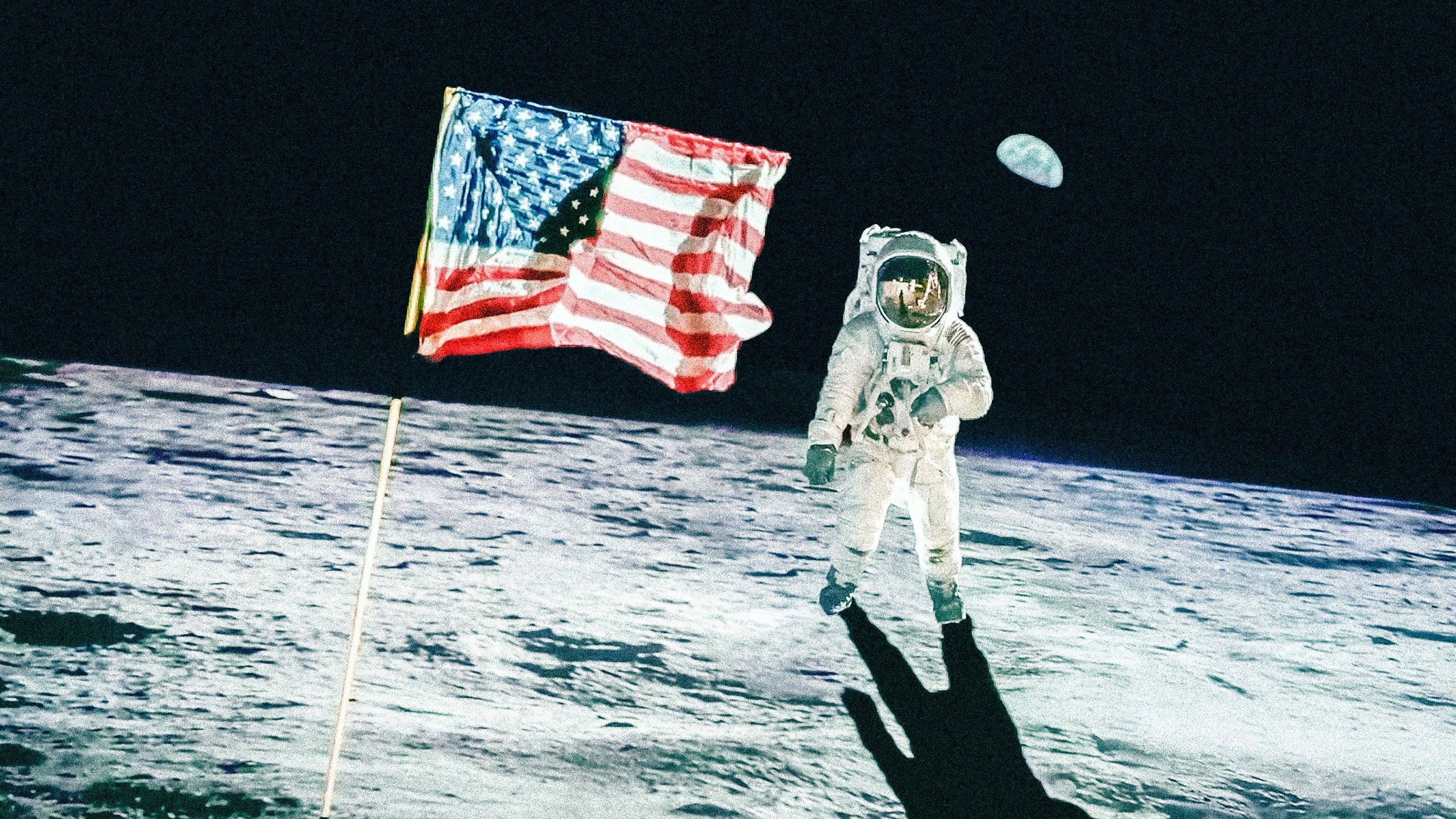 Neil Armstrong stands on the moon next to the American flag