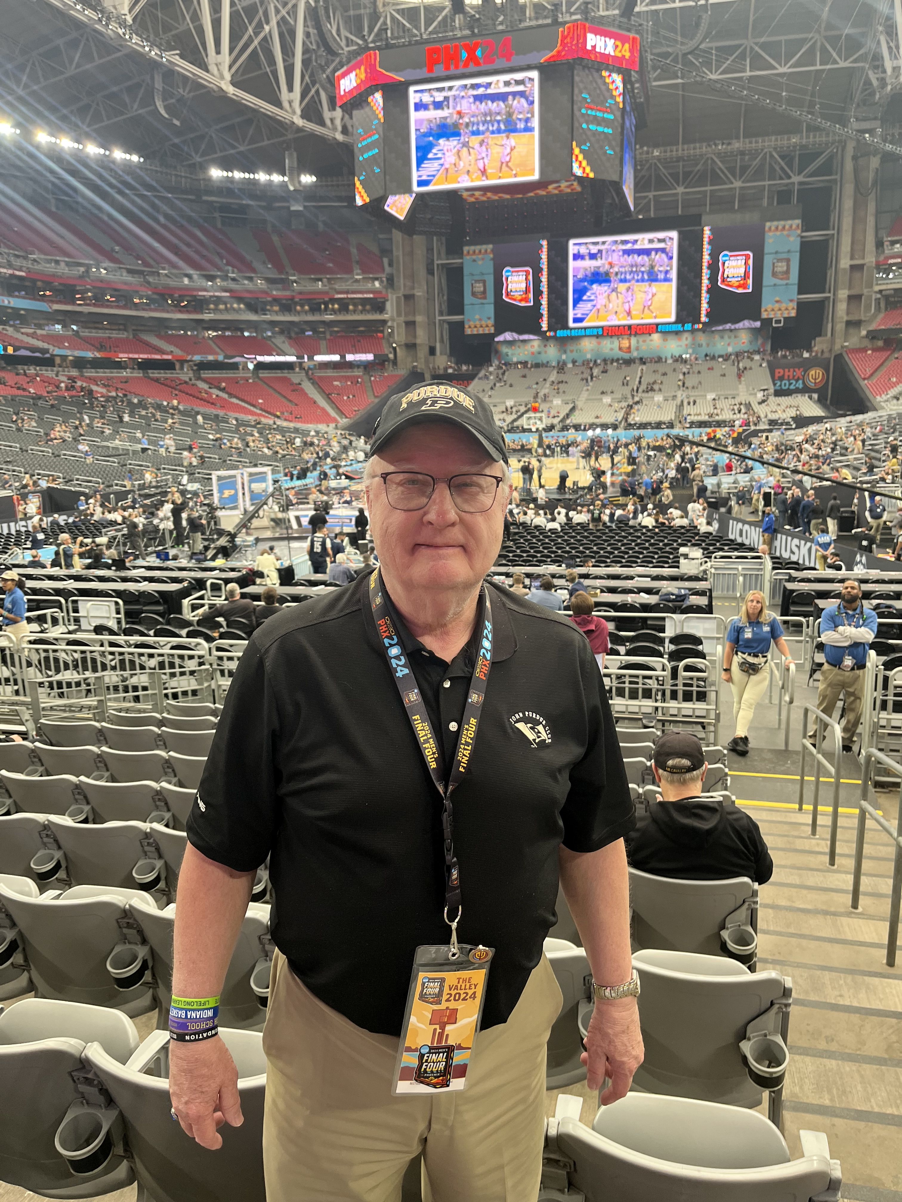 Greg Humnicky standing inside of a basketball stadium by the seats