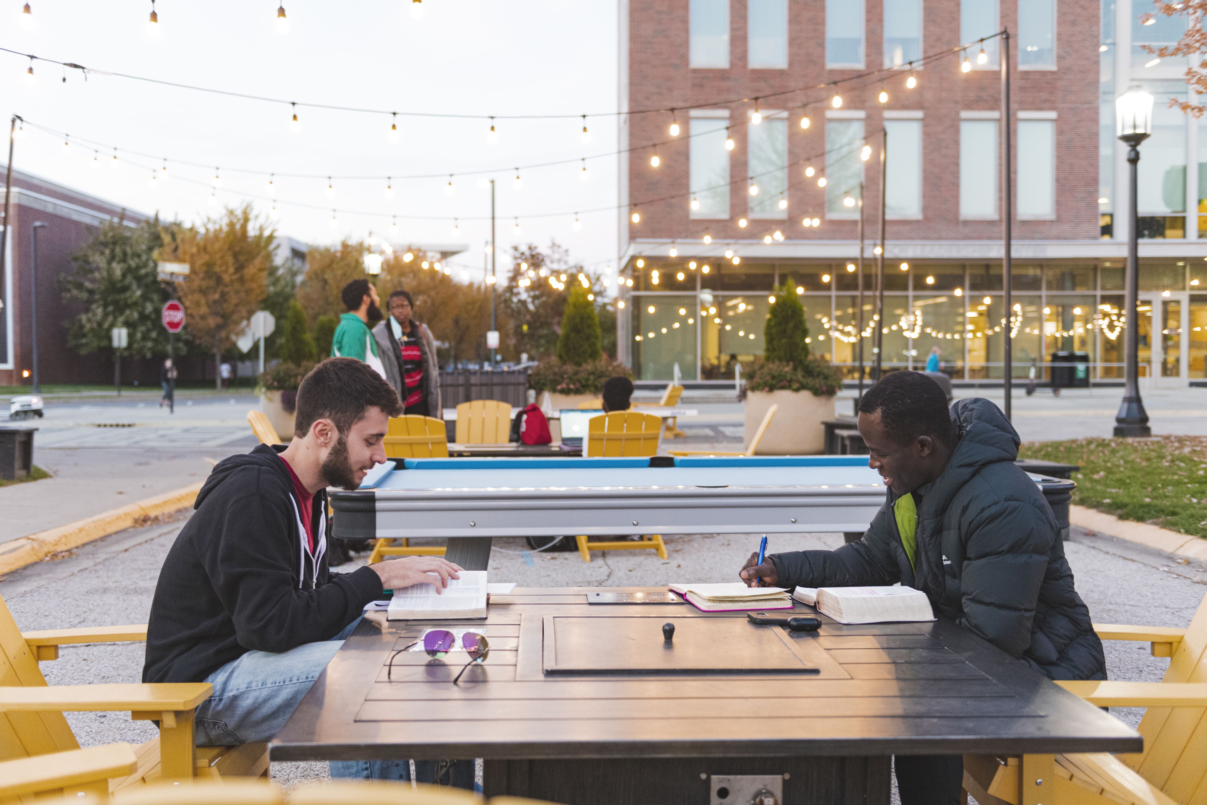 Two students read books outside 