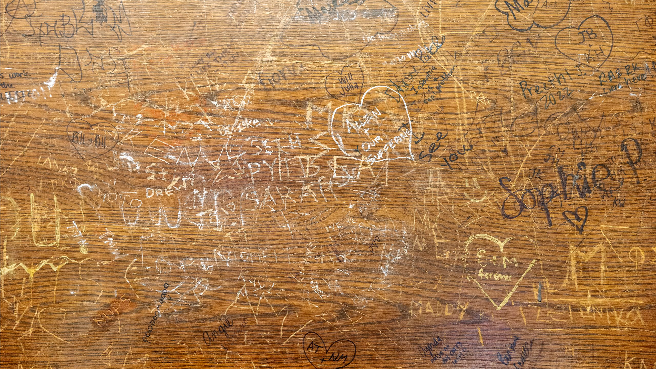 Close-up of hundreds of signatures etched and painted on the surface