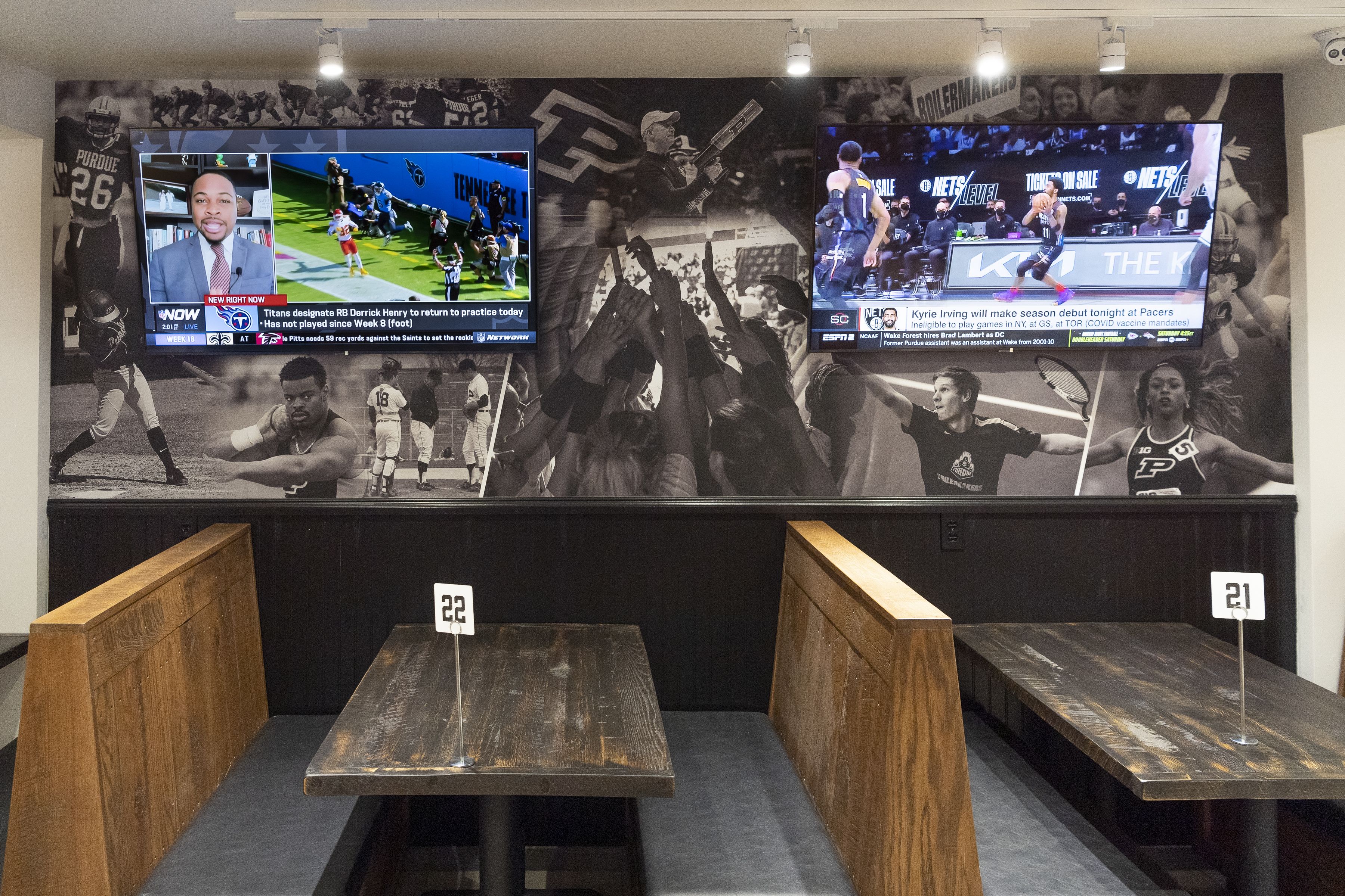 Wood dining booths and two large televisions mounted on the wall