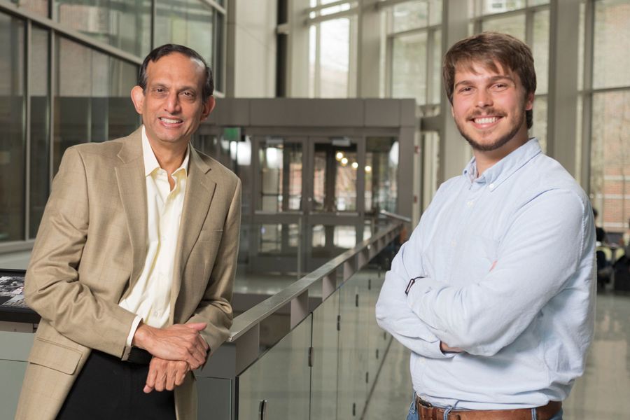 The image shows two men smiling