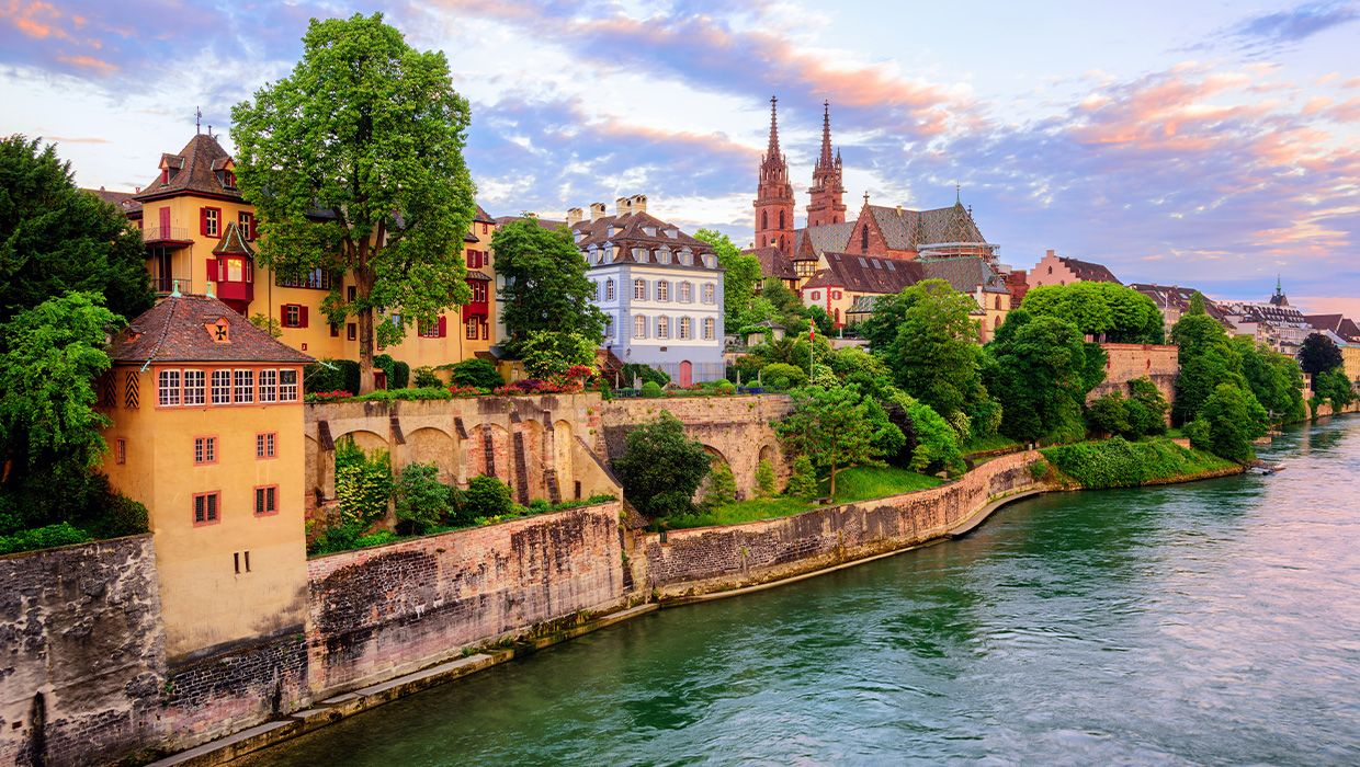 The Old Town of Basel with red stone; Munster Cathedral and the Rhine River, Switzerland, in dramatic sunset light